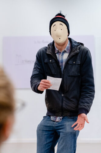 een persoon met een masker op die aan het acteren is